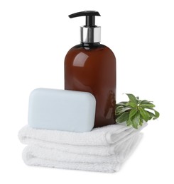 Soap bar, dispenser and stack of terry towels on white background