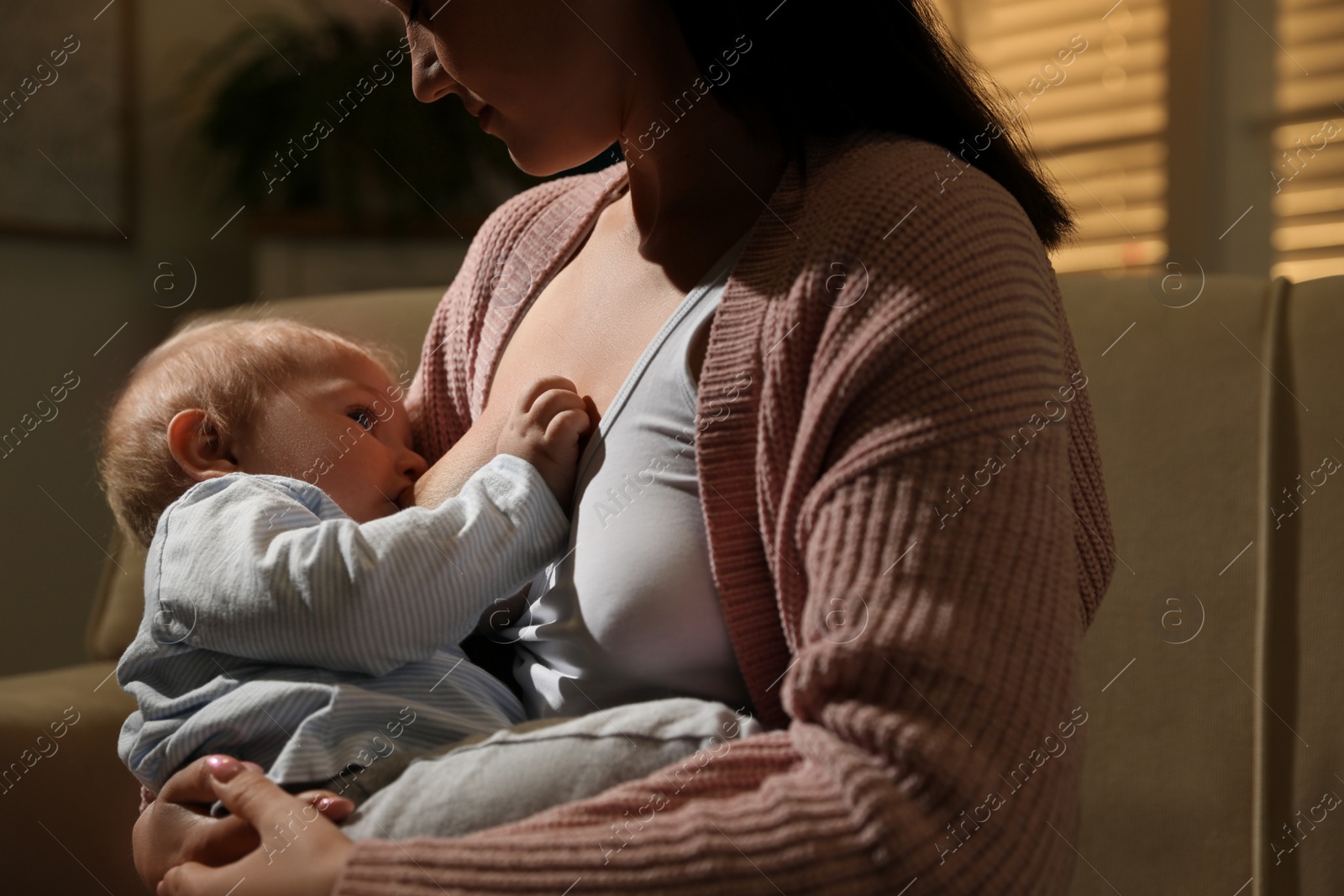 Photo of Woman breastfeeding her little baby at home