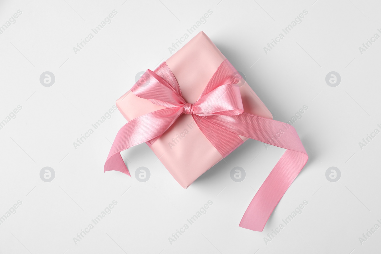 Photo of Beautiful gift box with pink bow on white background, top view