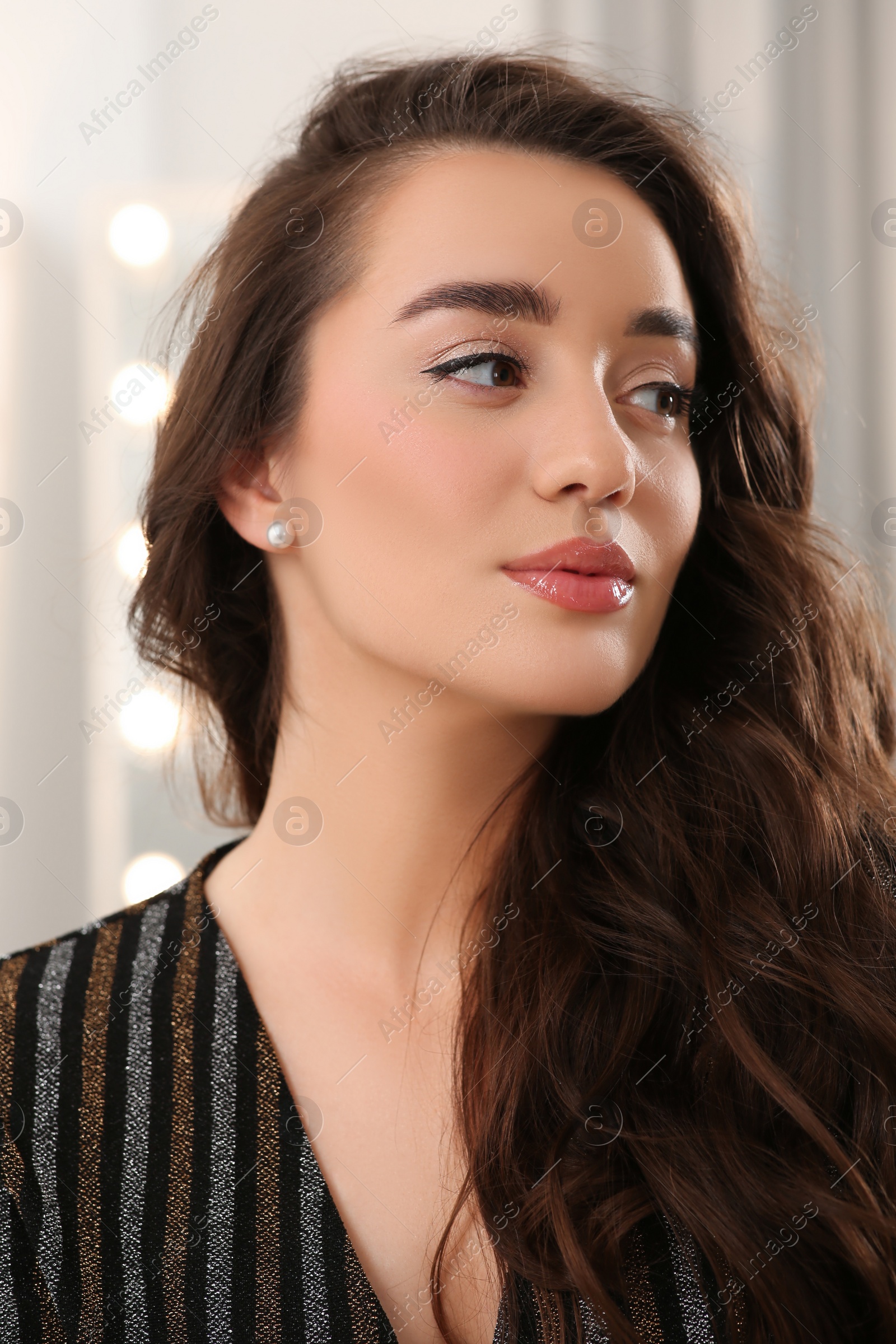 Photo of Portrait of beautiful young woman with wavy brown hair indoors