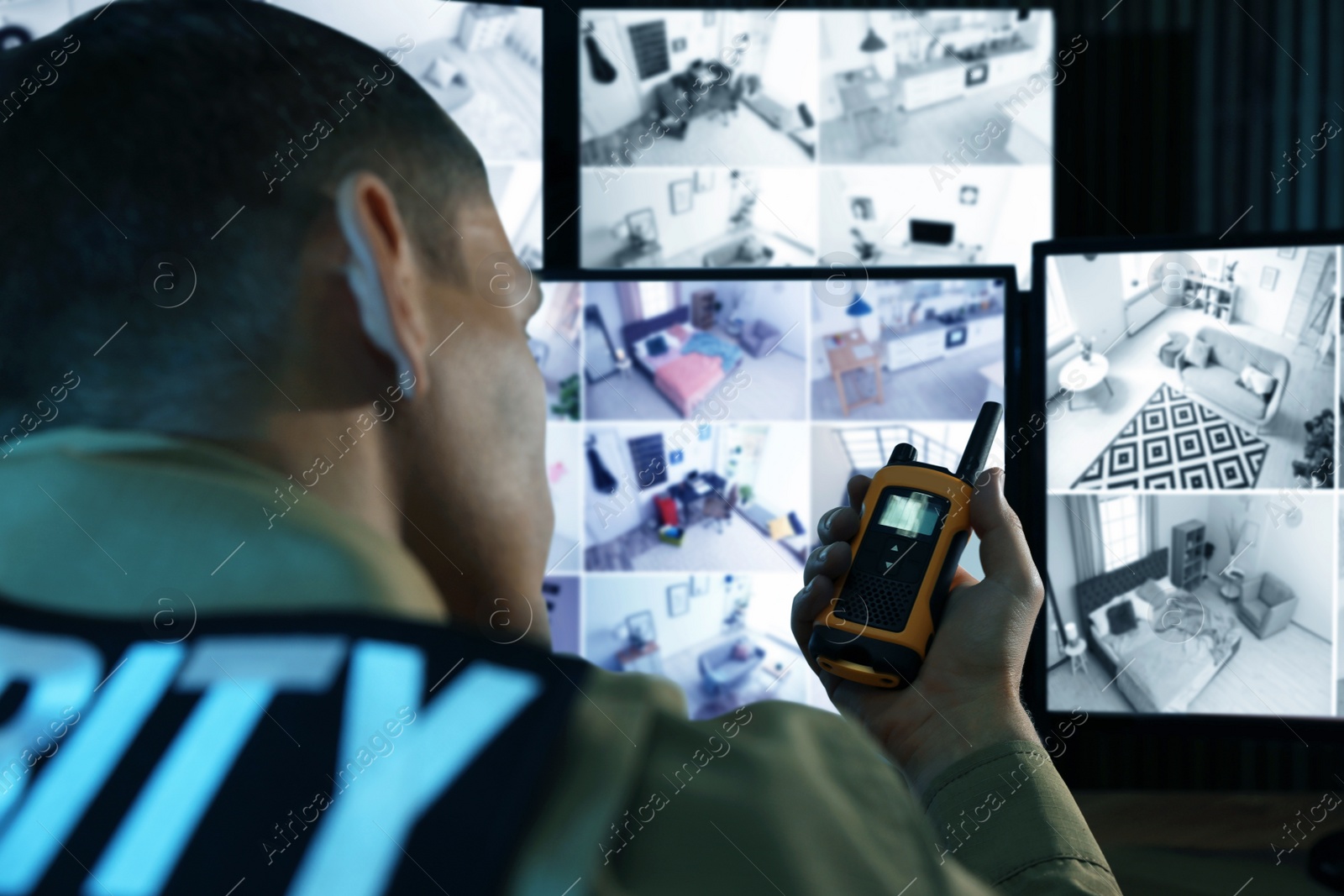 Photo of Security guard with portable transmitter monitoring modern CCTV cameras indoors