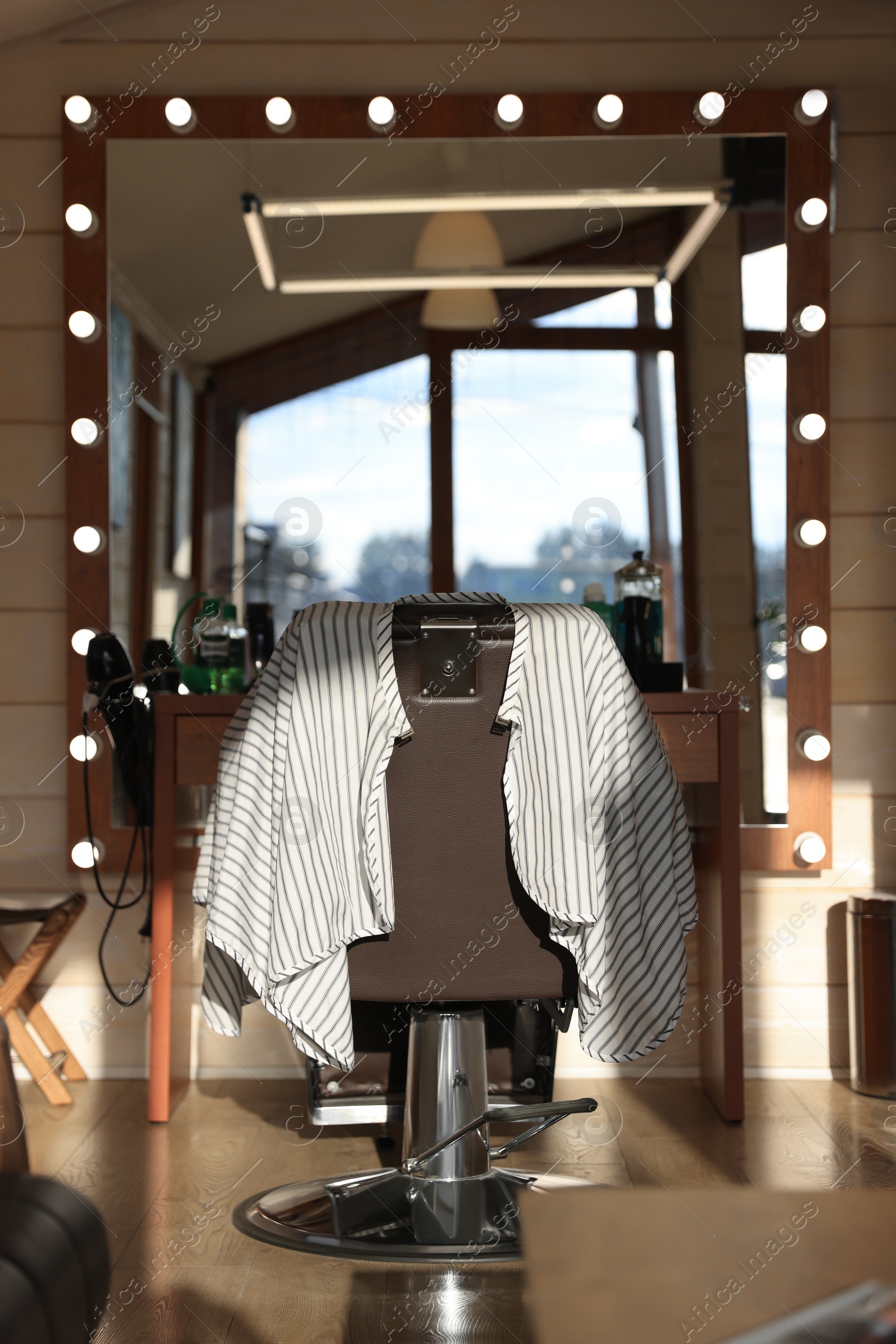 Photo of Stylish hairdresser's workplace with professional armchair in barbershop