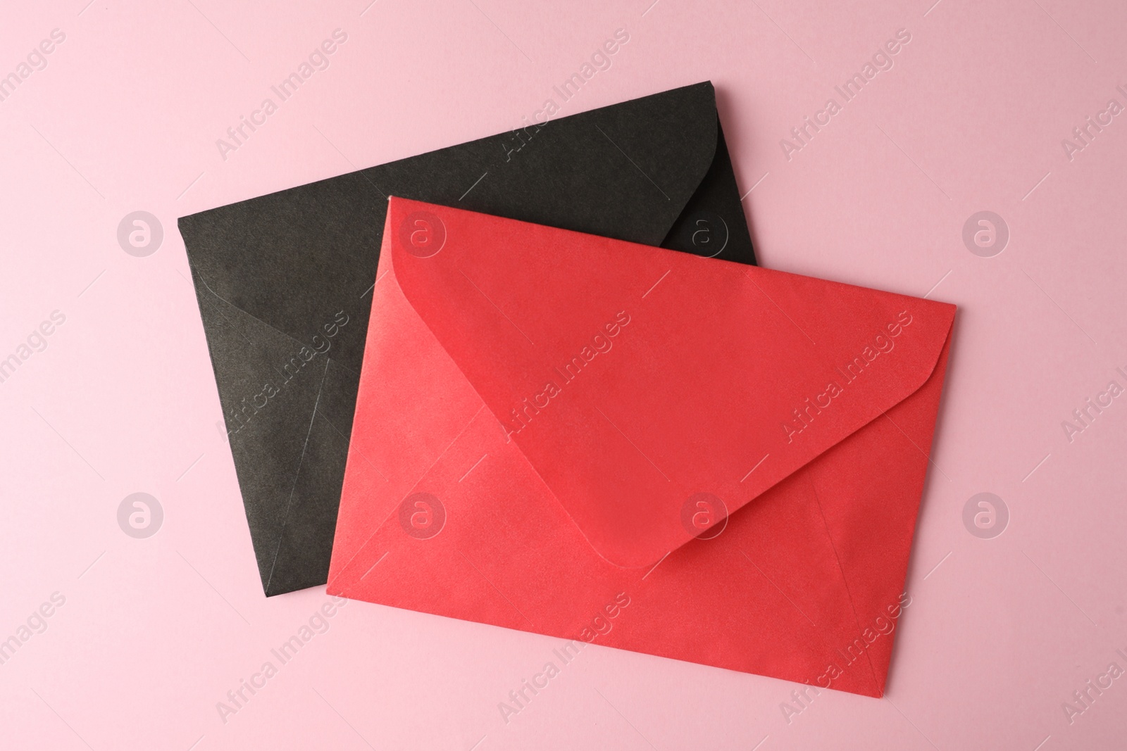 Photo of Colorful paper envelopes on pink background, top view