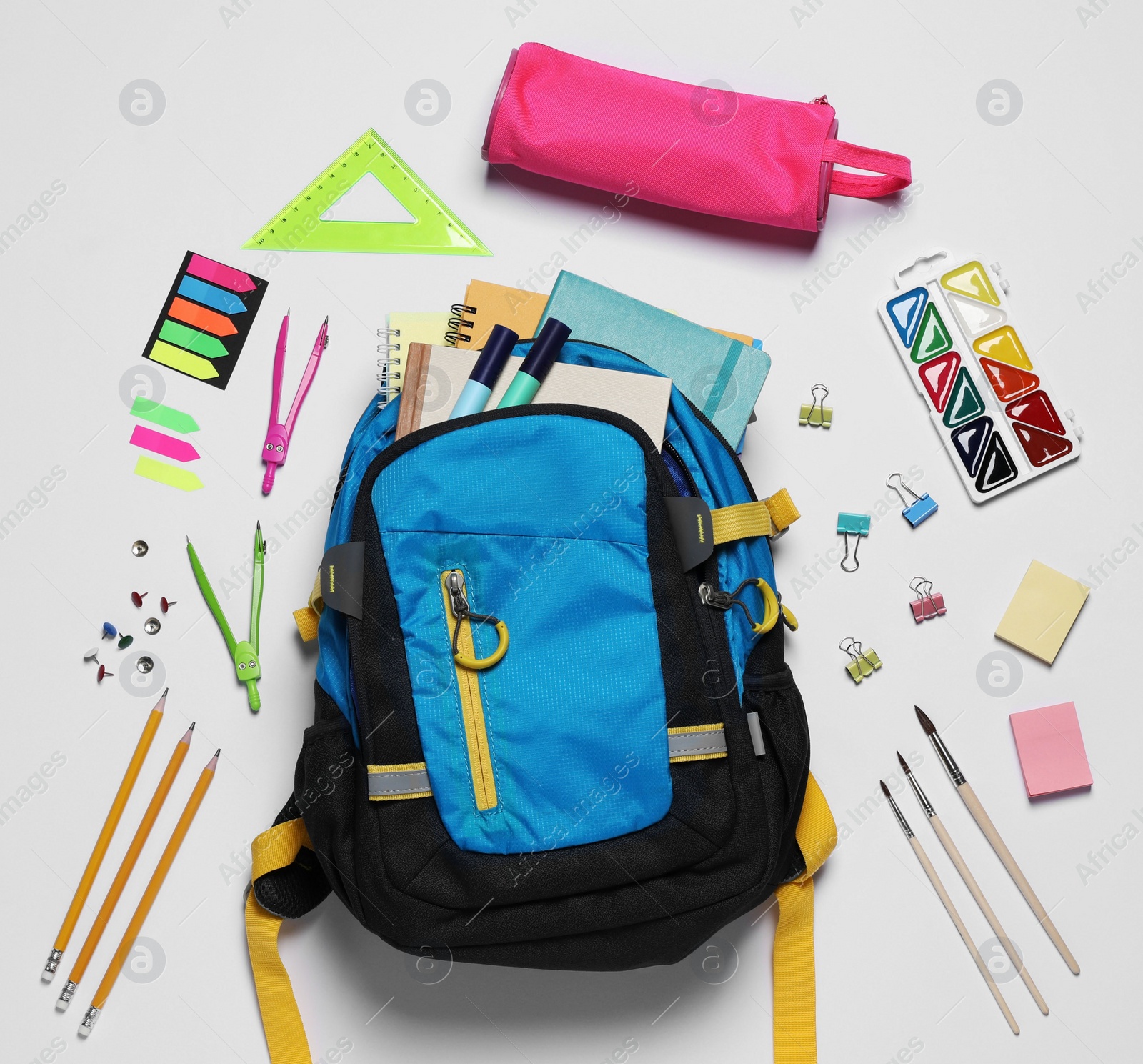 Photo of Backpack with different school stationery on white background, flat lay