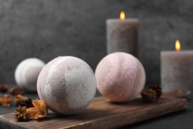 Photo of Bath bombs, candles and dry flowers on black table, closeup