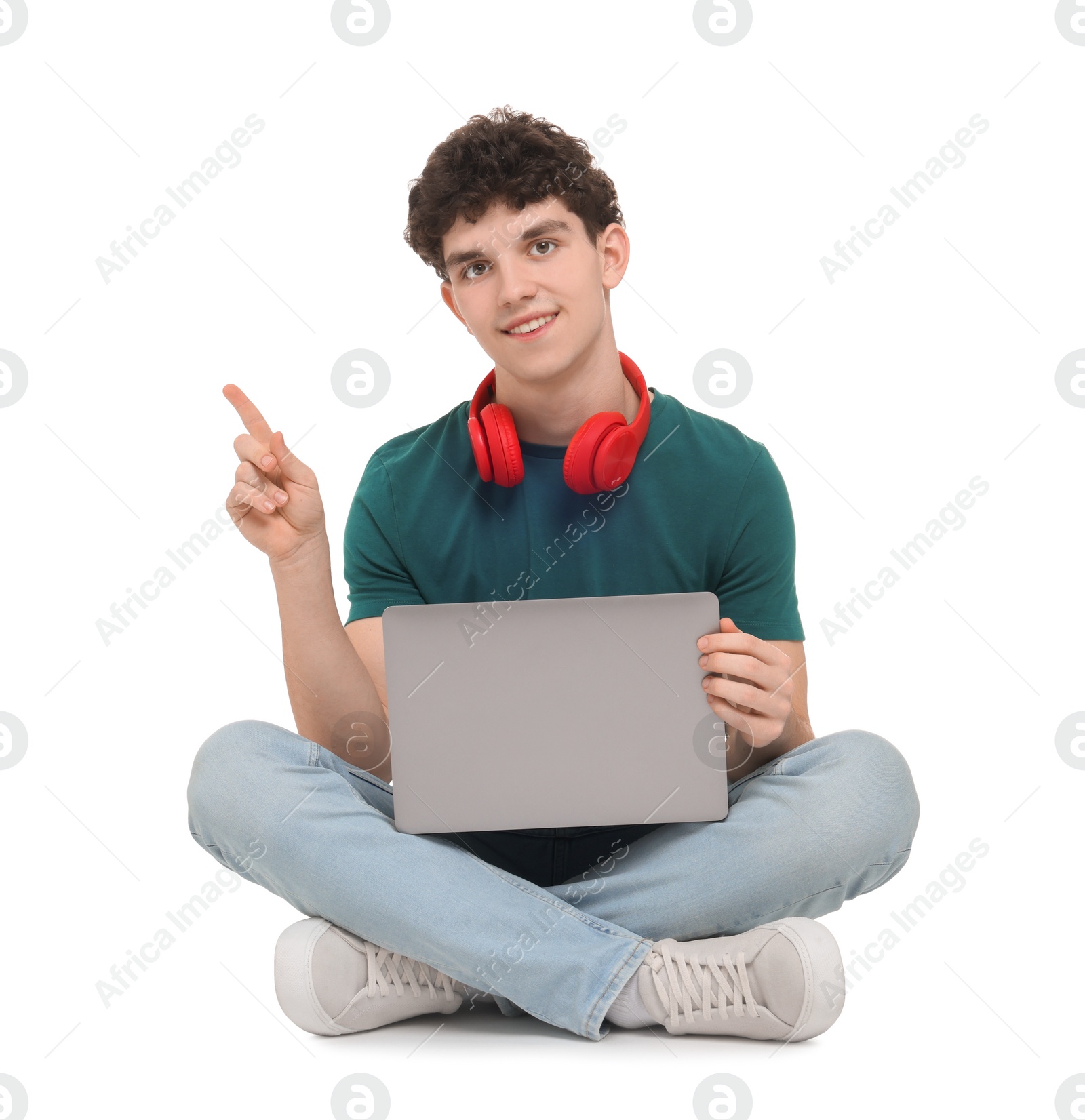 Photo of Portrait of student with laptop and headphones sitting on white background