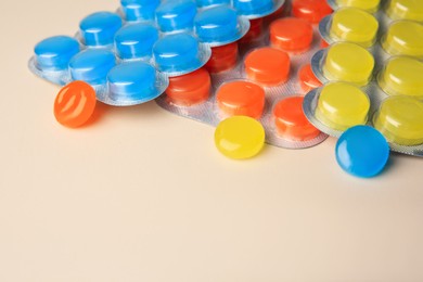 Blisters with cough drops on beige background, closeup. Space for text