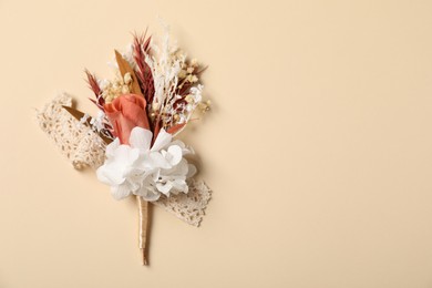 Stylish boutonniere on beige background, top view. Space for text