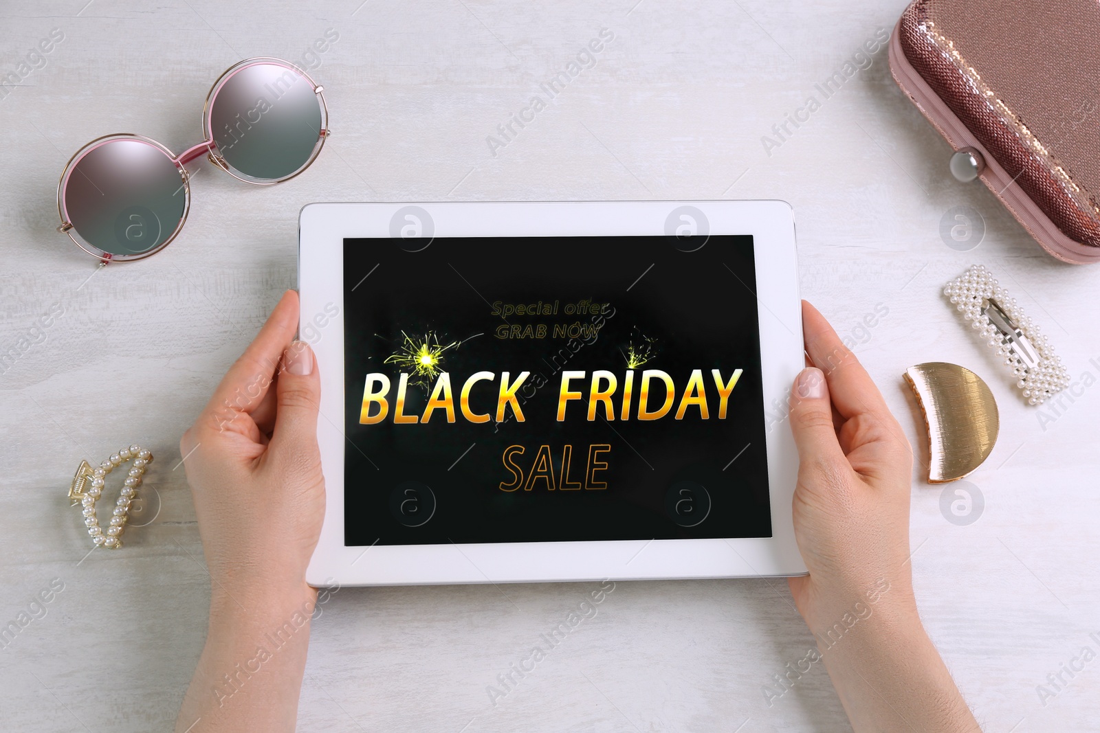 Photo of Woman using tablet with Black Friday announcement at white table, top view