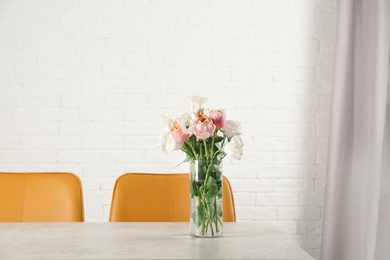 Vase with beautiful flowers as element of interior design on table in room