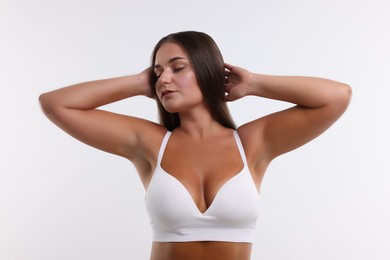 Photo of Portrait of young woman with beautiful breast on white background