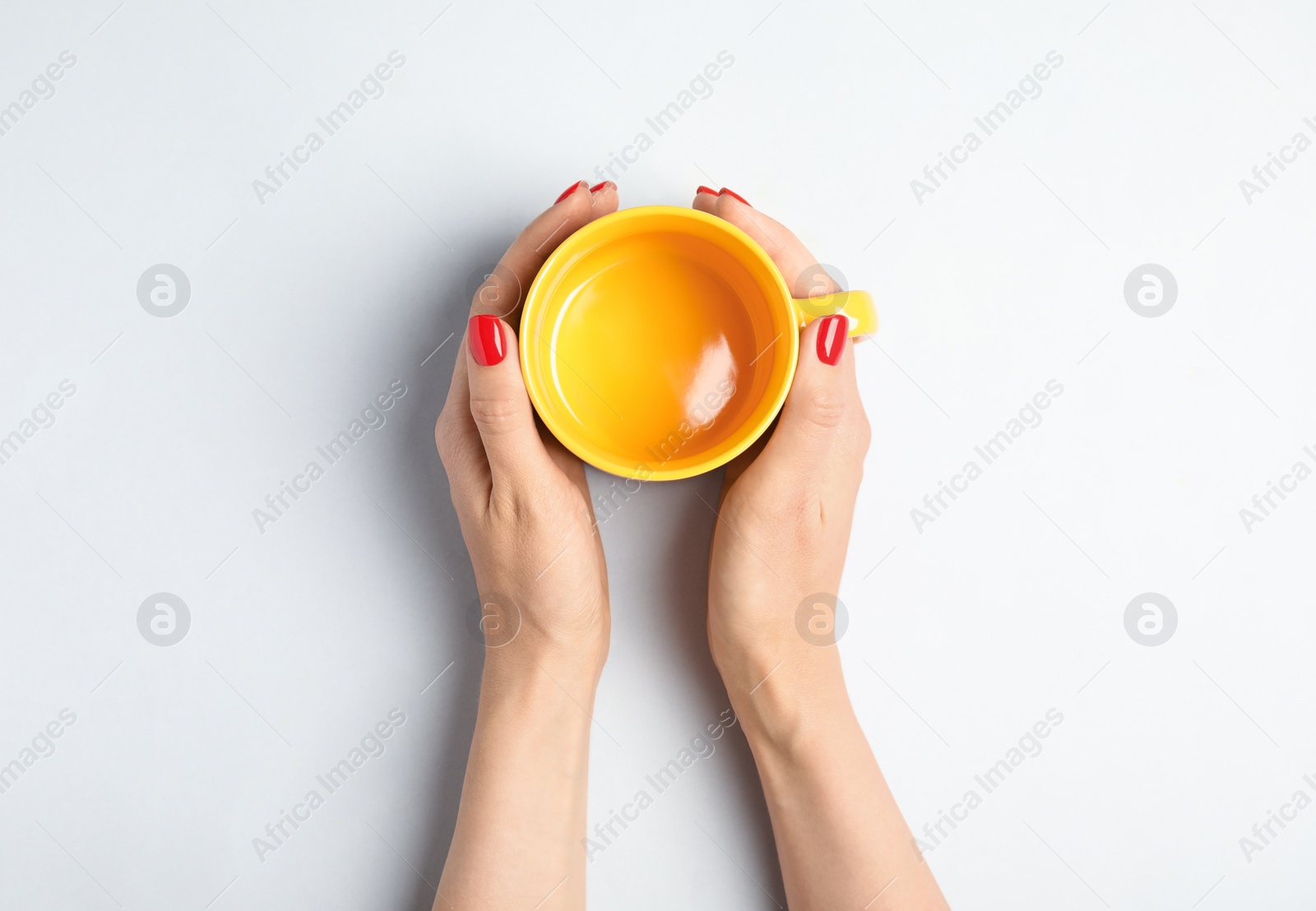 Photo of Woman with empty cup on light background, top view