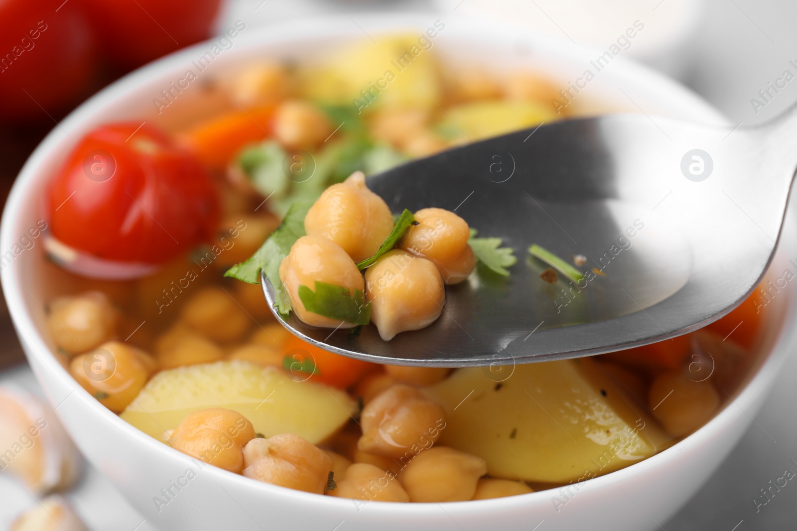 Photo of Eating tasty chickpea soup on table, closeup