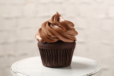 Photo of Delicious chocolate cupcake with cream on white table, closeup