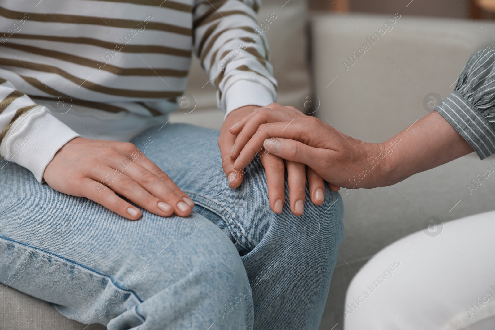 Photo of Psychotherapist holding patient's hand indoors, closeup view