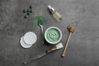 Photo of Flat lay composition with spirulina facial mask and ingredients on grey table