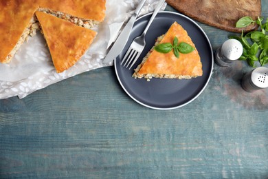 Delicious meat pie served on blue wooden table, flat lay. Space for text