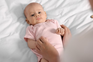 Mother with her cute little baby on white sheets