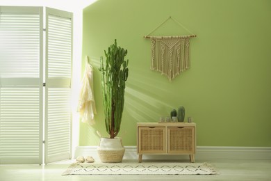 Hallway interior with cactus in pot and wooden furniture