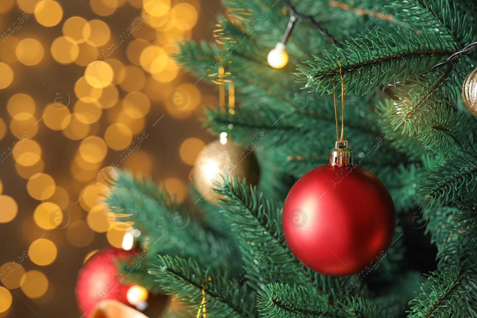 Photo of Beautiful Christmas tree with decor against blurred lights on background