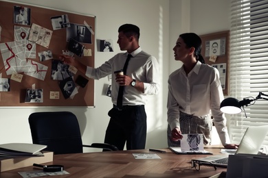 Photo of Professional detectives working on case in office