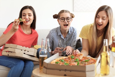 Young people having fun party with delicious pizza indoors