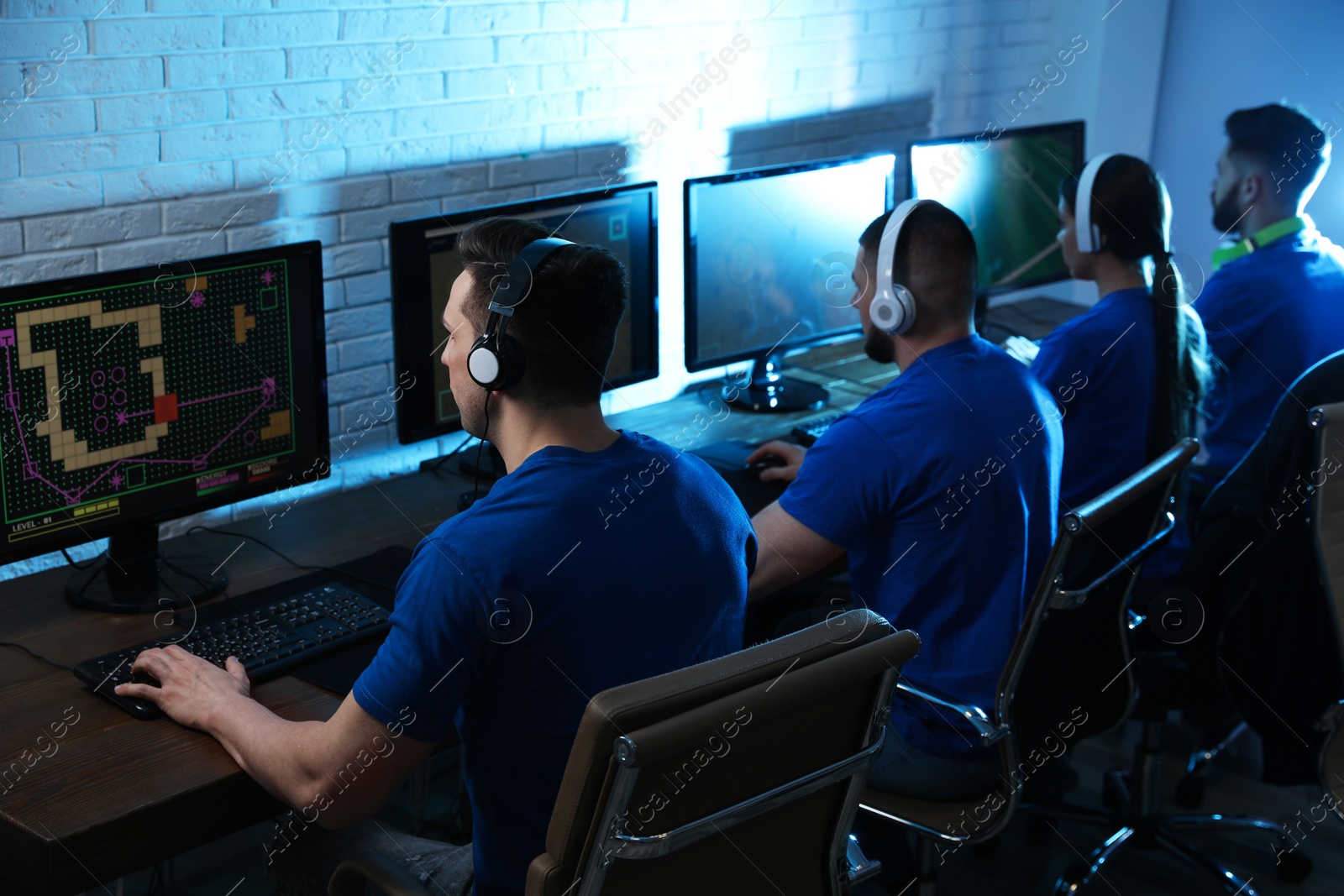 Photo of Young people playing video games on computers indoors. Esports tournament