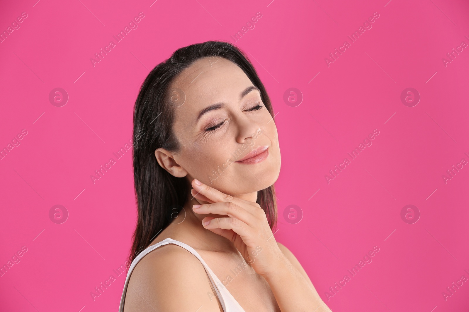 Photo of Portrait of beautiful mature woman on pink background