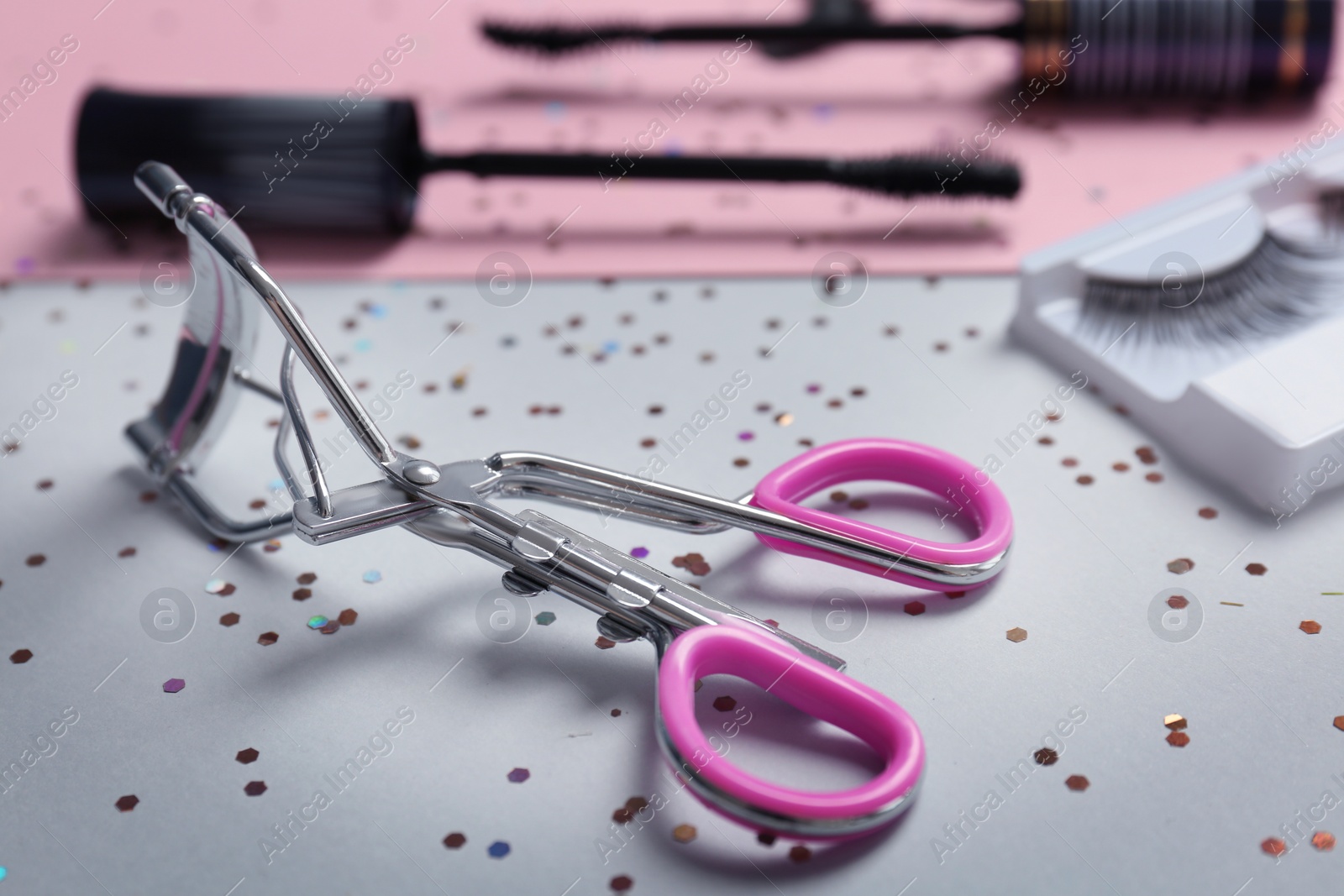 Photo of Eyelash curler on grey background, closeup