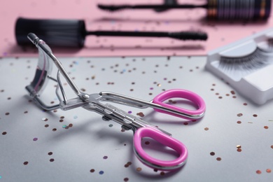 Eyelash curler on grey background, closeup