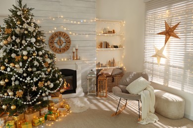 Photo of Decorated Christmas tree with gift boxes and fireplace in stylish living room interior