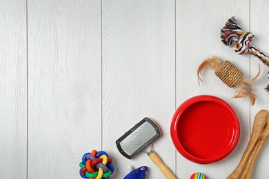 Flat lay composition with accessories for dog and cat on wooden background. Pet care