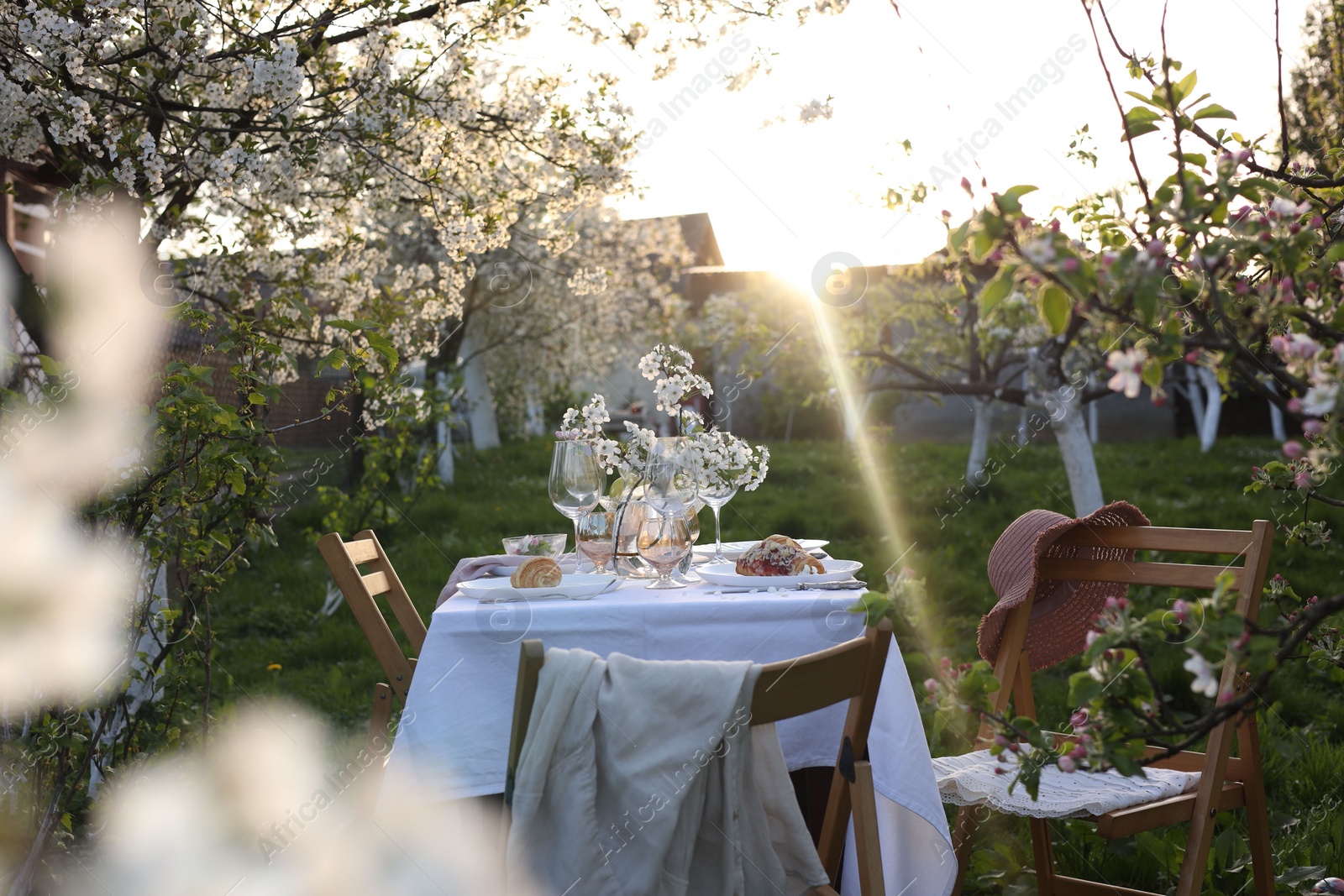 Photo of Stylish table setting with beautiful spring flowers in garden