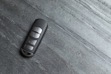 Car smart key on grey background, top view with space for text