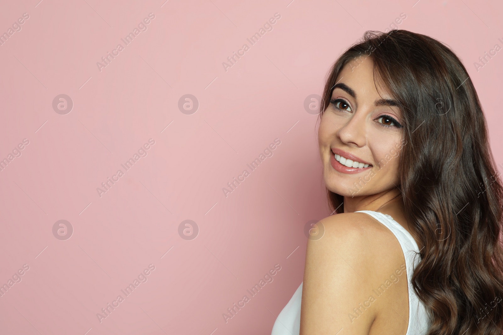 Photo of Beautiful woman with shiny wavy hair on color background. Space for text