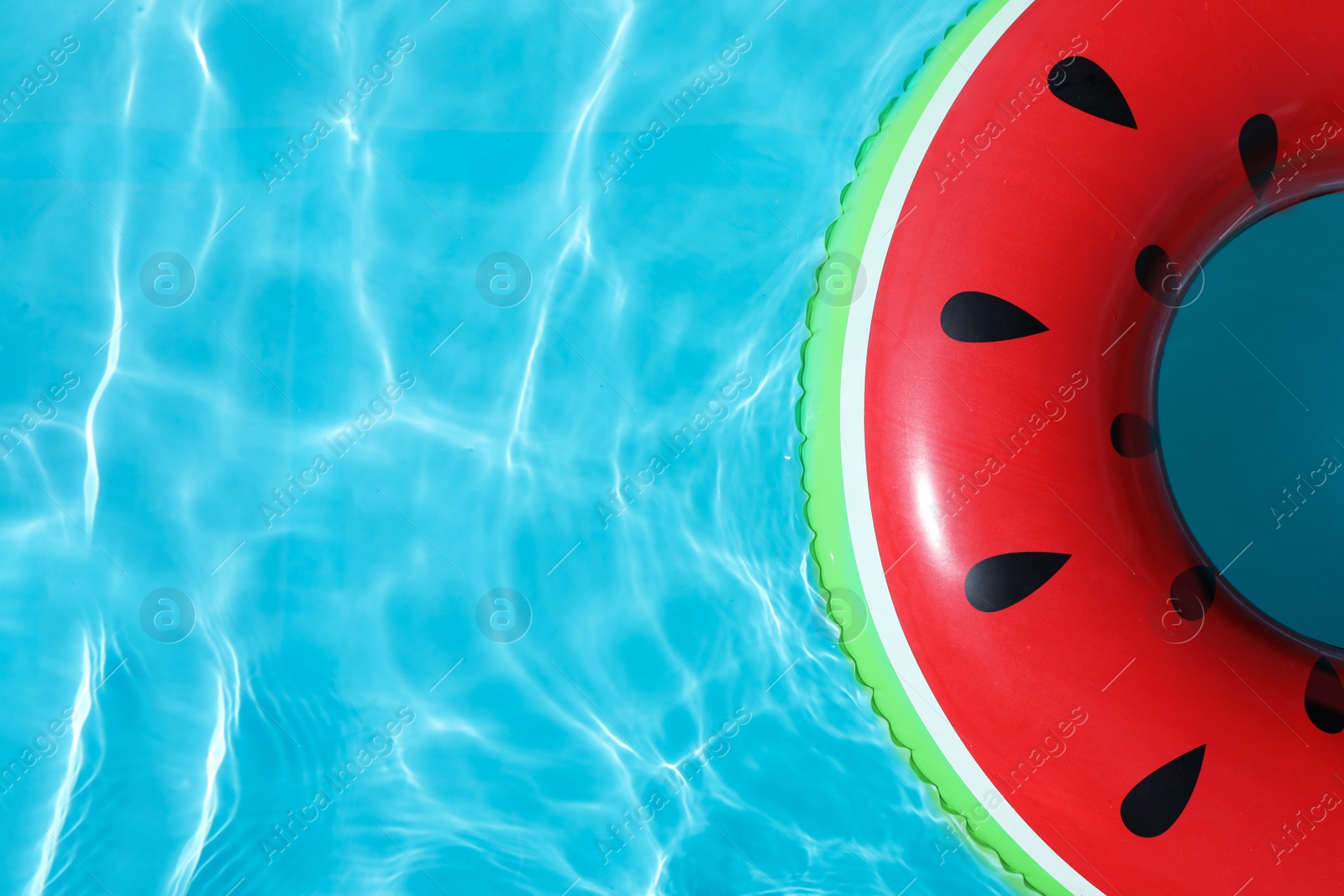 Photo of Inflatable ring floating in swimming pool on sunny day, top view with space for text