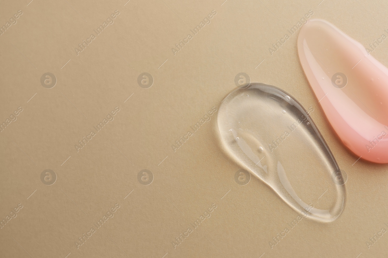 Photo of Samples of cosmetic gels on beige background, top view. Space for text