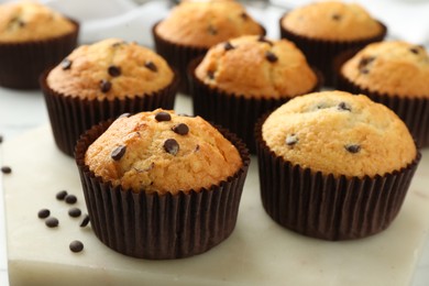 Photo of Delicious sweet muffins with chocolate chips on table, closeup