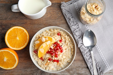 Flat lay composition with quinoa porridge and cream served for breakfast on wooden background