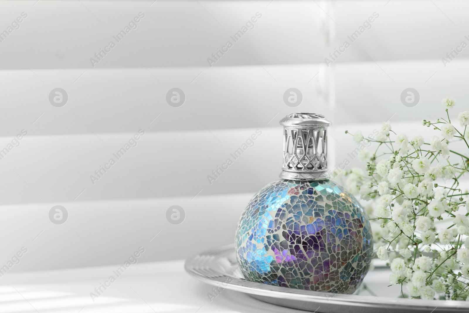 Photo of Beautiful catalytic purifying lamp and flowers on window sill, space for text. Interior element