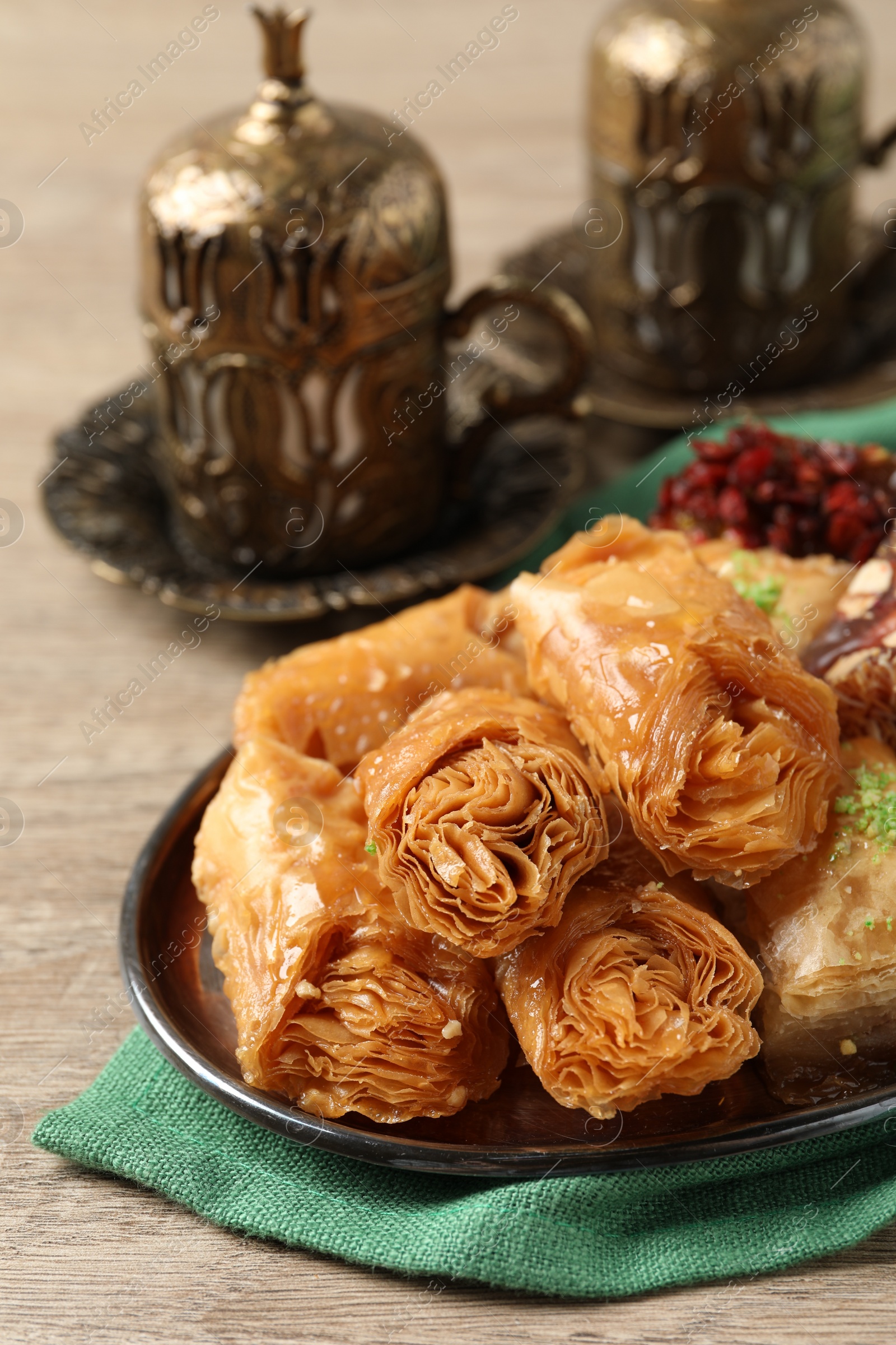 Photo of Tea and baklava dessert and Turkish delight served in vintage tea set on wooden table, closeup. Space for text