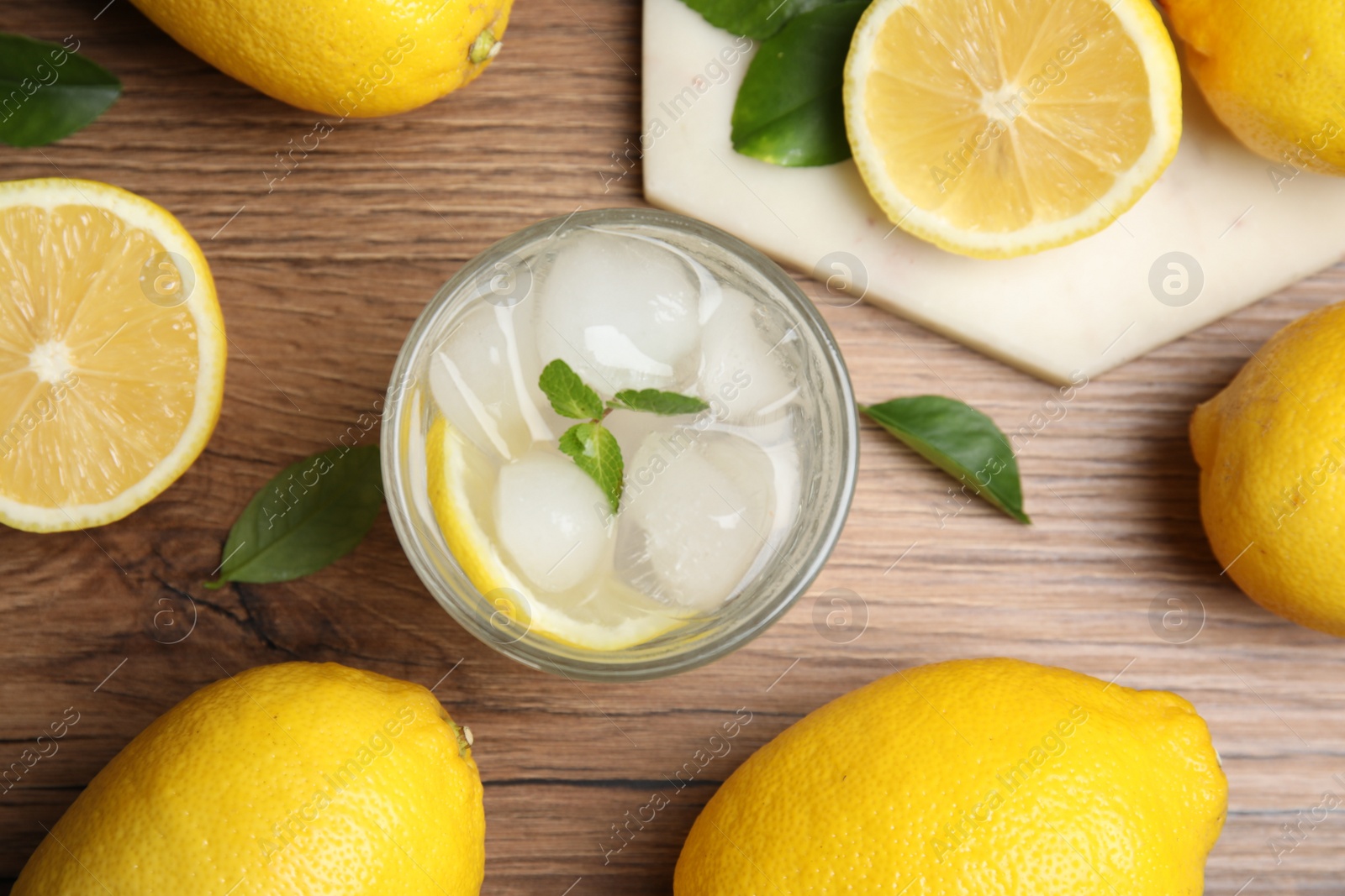 Photo of Cool freshly made lemonade and fruits on wooden table, flat lay