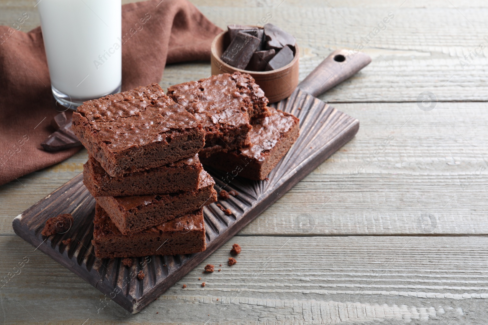 Photo of Delicious chocolate brownies on wooden table. Space for text