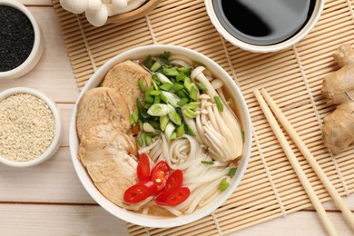 Photo of Delicious ramen with meat and ingredients on white wooden table, flat lay. Noodle soup