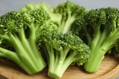 Photo of Fresh green broccoli on wooden board, closeup