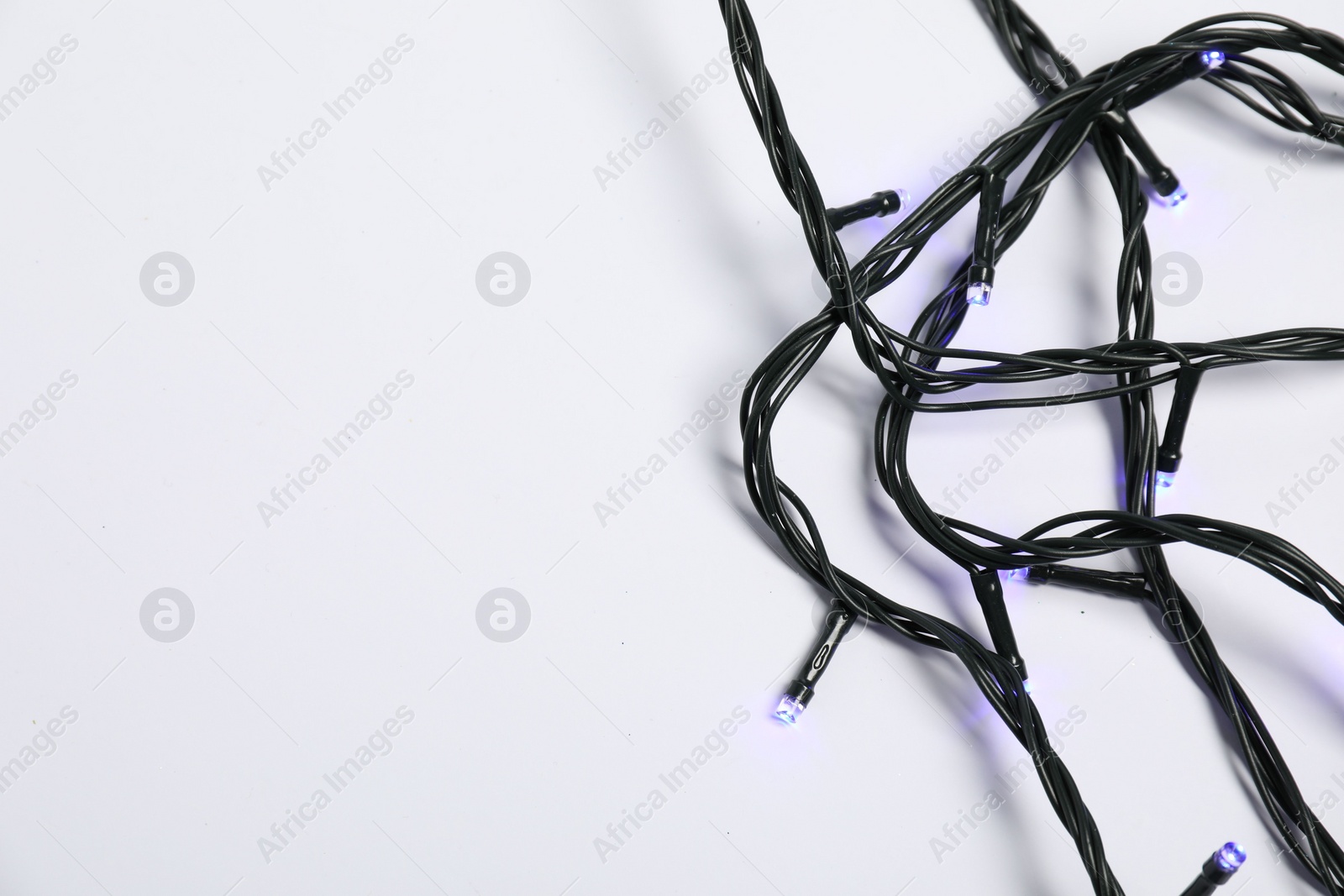 Photo of Beautiful Christmas lights on white background, top view