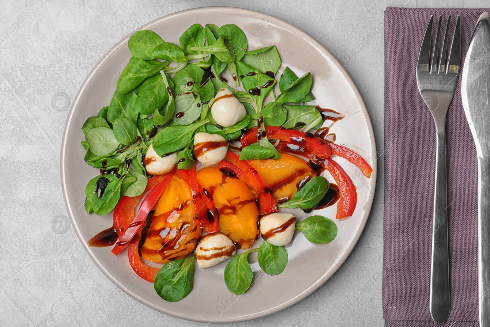 Photo of Vegetable salad with balsamic vinegar on grey background, top view