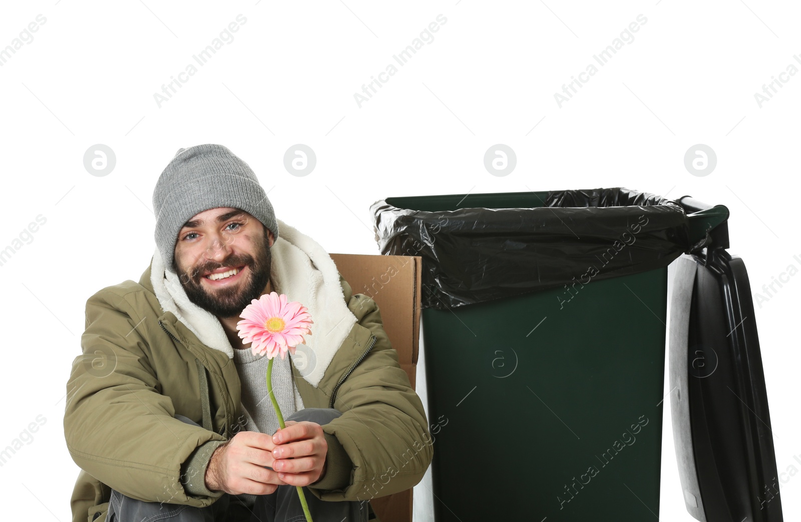 Photo of Poor homeless man with flower near trash bin isolated on white