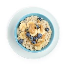 Photo of Tasty oatmeal with banana, blueberries and peanut butter in bowl isolated on white, top view