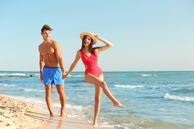 Photo of Happy young couple having fun at beach on sunny day